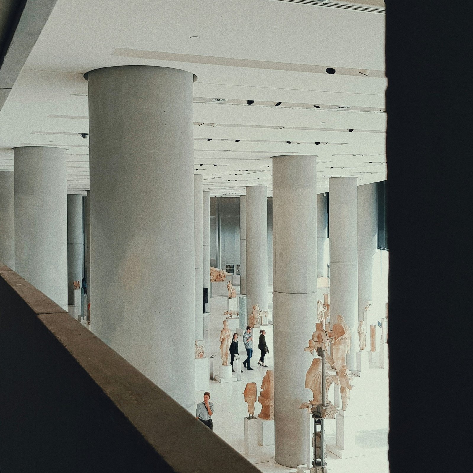 view of people walking inside building with columns